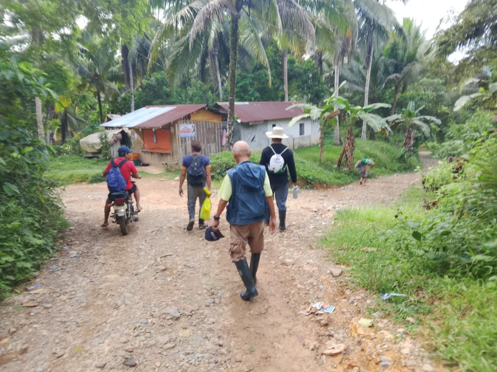 People walking along a rural path in a local BiField community